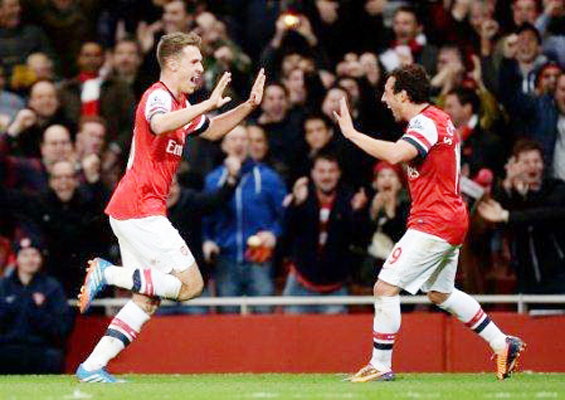 Aaron Ramsey (trái) và Santi Cazorla cùng ghi bàn vào lưới Liverpool giúp Arsenal giữ vững ngôi đầu bảng.